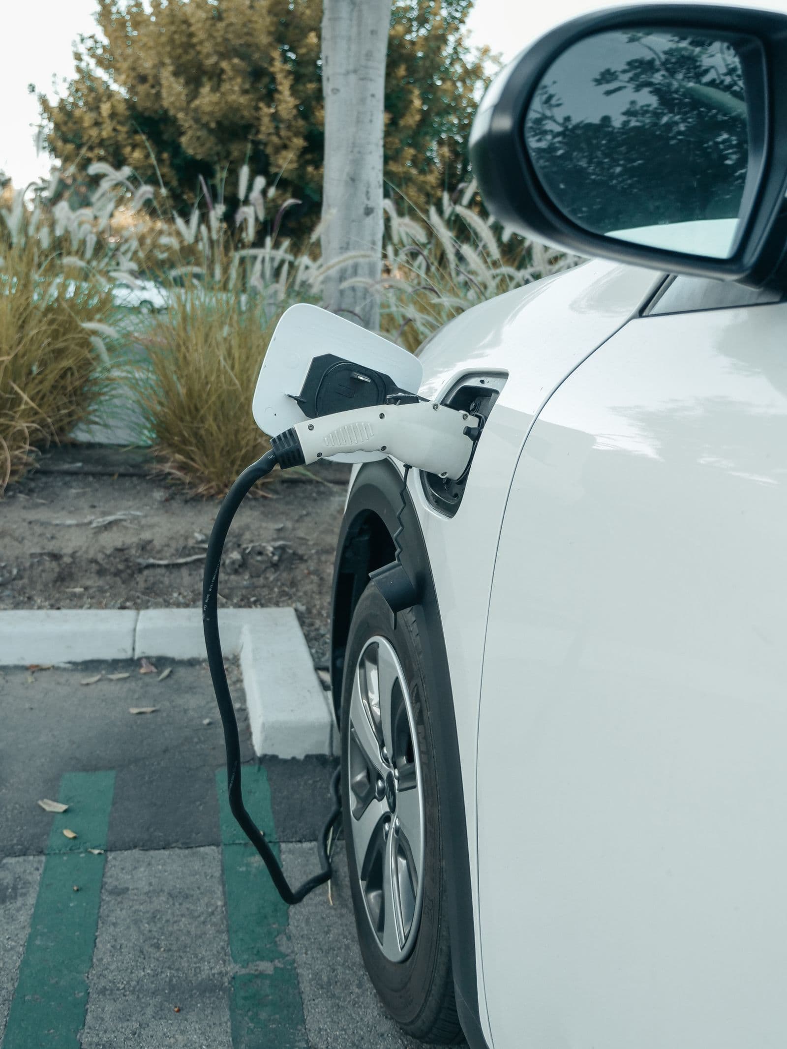 White electric car plugged in to charge